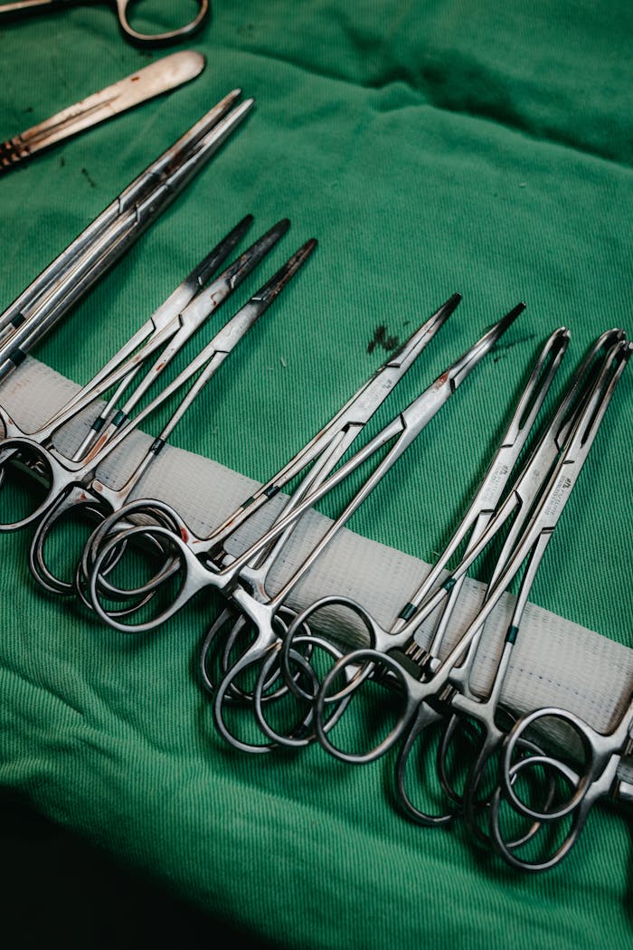 services-03 Close-up of surgical tools organized on a green cloth, highlighting medical equipment.