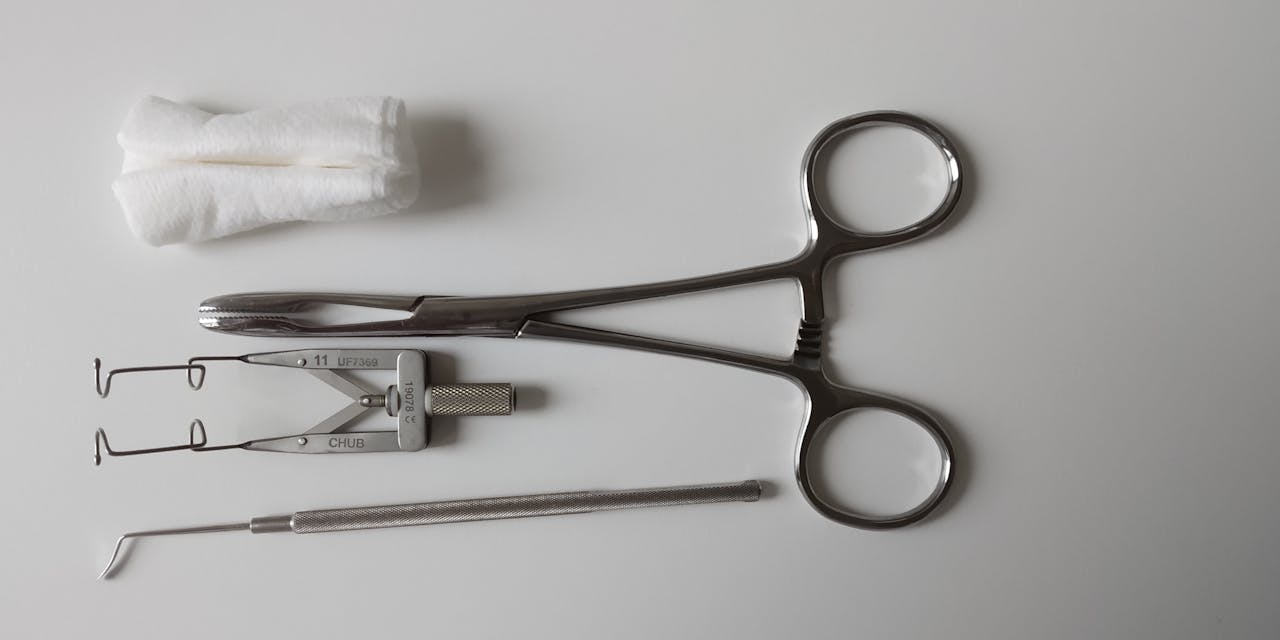 A set of surgical tools including scissors on a clean white background.